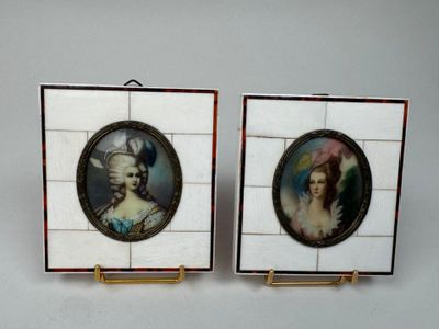 pair of miniature portraits of a woman and a man on a tile wall