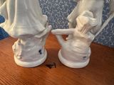 two figurines of a woman and a man on a table