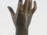 bronze statue of a hand with a ring on it ' s finger