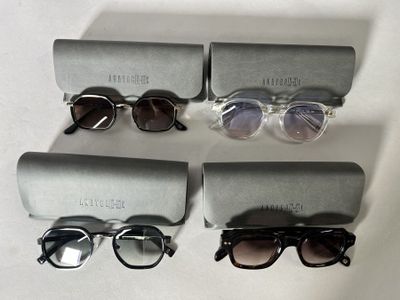 three pairs of sunglasses are sitting on a table next to a pair of glasses