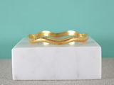 a close up of a gold ring on a marble block