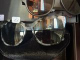 Plusieurs paires de lunettes de soleil sont exposées dans une vitrine.