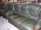 un canapé en cuir vert et deux fauteuils dans une pièce