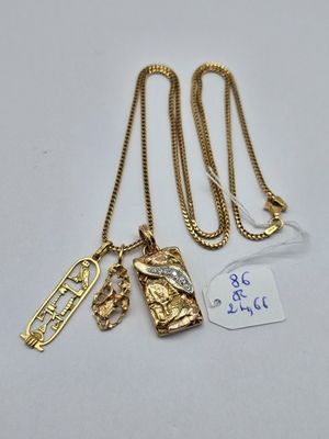 trois colliers en or ornés de breloques et de pendentifs