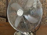 a table with a fan on it and a chair in the background