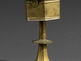 un bougeoir ancien en laiton surmonté d'une boîte