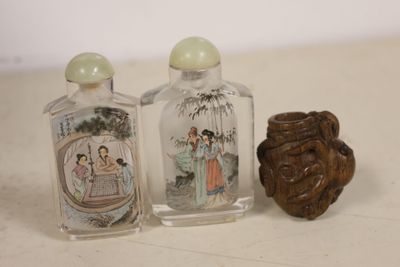 three glass bottles with asian designs on them on a table