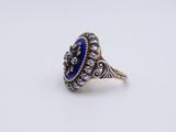 a close up of a silver ring with a blue stone in it