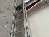 a ladder that is leaning against a wall next to a piece of paper