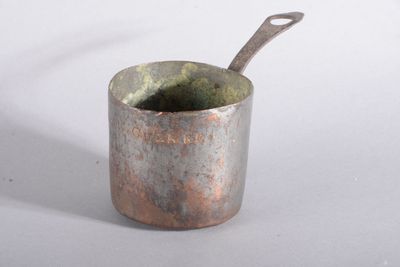 une petite tasse en métal contenant une cuillère