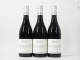 trois bouteilles de vin posées sur une table blanche