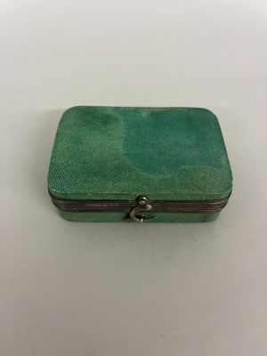 une petite boîte verte posée sur une table blanche