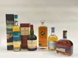 plusieurs bouteilles de différents types d'alcool posées sur une surface blanche