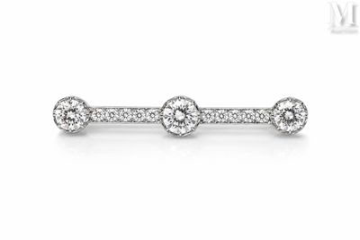 a white gold diamond bar ring with three round diamonds