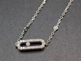 a close up of a diamond necklace on a black surface
