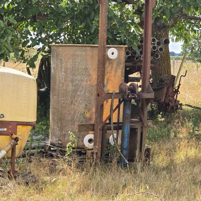 un tracteur qui est garé dans l'herbe, près d'un arbre