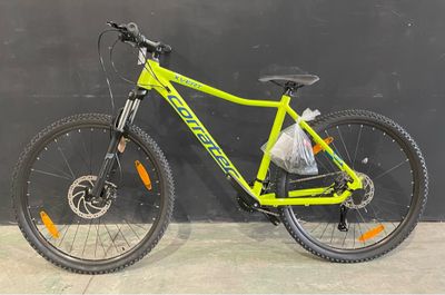 le vélo est garé contre le mur, avec un sac à l'arrière