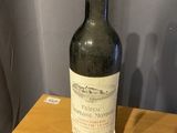une bouteille de vin posée sur une table devant un mur