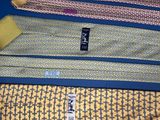 four different colored ties are lined up on a blue surface
