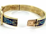 an image of a gold bracelet with a blue and white design
