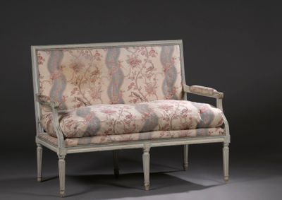 un canapé dont le dossier et les accoudoirs sont recouverts d'un tissu à motifs floraux