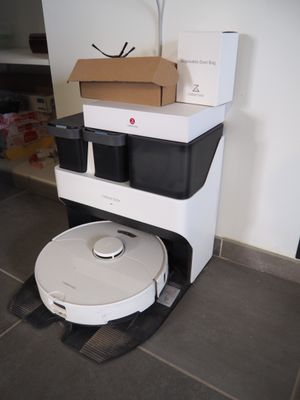 un robot assis par terre à côté d'une boîte