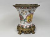 a vase that is sitting on a stand on a white surface