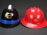 two firemen hats sitting next to each other on a table