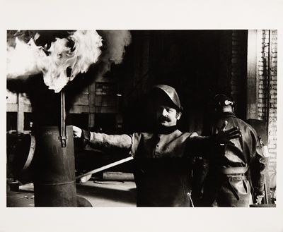 photographie en noir et blanc d'un homme tenant un extincteur devant une borne d'incendie