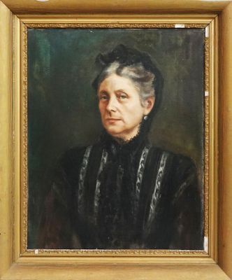 On y voit un tableau représentant une femme en robe noire, encadré dans un cadre doré.