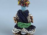 une image représentant une figurine de femme vêtue d'une robe bleue et portant des fleurs sur la tête