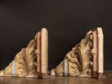 pair of carved bookends on wooden table with black background