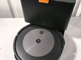 a close up of a robot vacuum on a table with a box