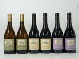 six bouteilles de vin sont alignées sur une table