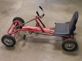 a small red tricycle with a black seat on the floor