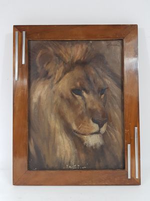 tableau représentant un lion, dans un cadre en bois, accroché à un mur blanc