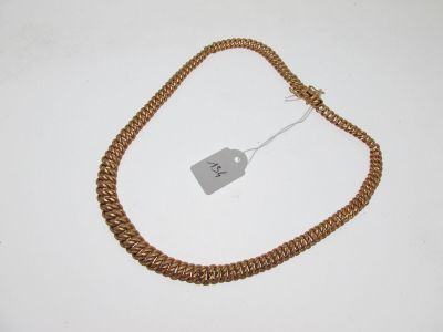 a close up of a necklace on a white surface with a price tag