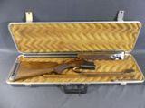 une valise ouverte contenant une arme à feu et d'autres objets