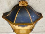 a blue and gold lamp hanging on the wall