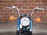 a blue motorcycle parked in front of a brick wall