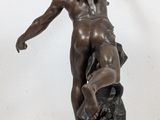 bronze statue of a woman holding a bird on a marble base