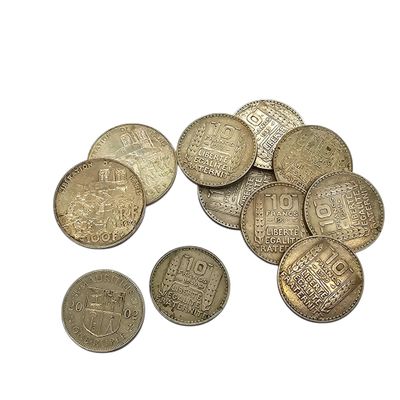 some coins are sitting on top of each other on a white surface
