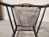 a metal chair with a mesh back and a wooden seat