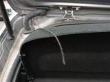 a car trunk with a black seat belt and a phone in the trunk