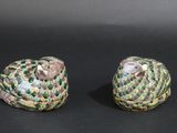 pair of green and white ceramic figurines of birds on a black background