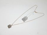 deux colliers avec des étiquettes attachées, posés sur une surface blanche