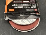 two sanding discs on a table with a box of them