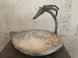 a sculpture of a bird sitting on top of a bowl