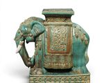 a statue of an elephant with a seat on it ' s back