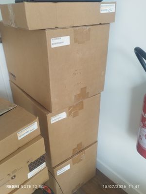 des cartons empilés les uns sur les autres dans une pièce équipée d'un extincteur